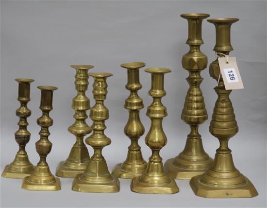 Four pairs of brass candlesticks